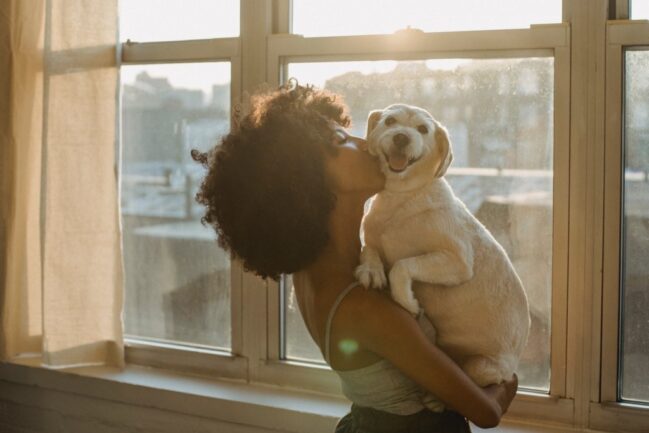 Black woman kissing dog