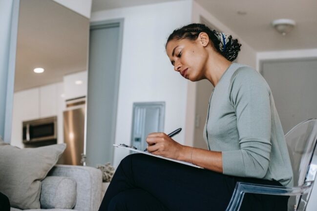 Woman working as a counsellor writing on a notepad