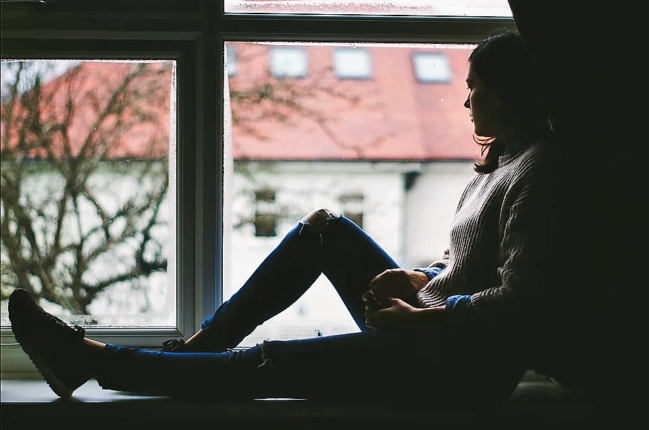 Girl sat next to window