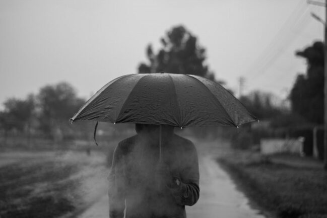 Man walking in the rain with umbrella