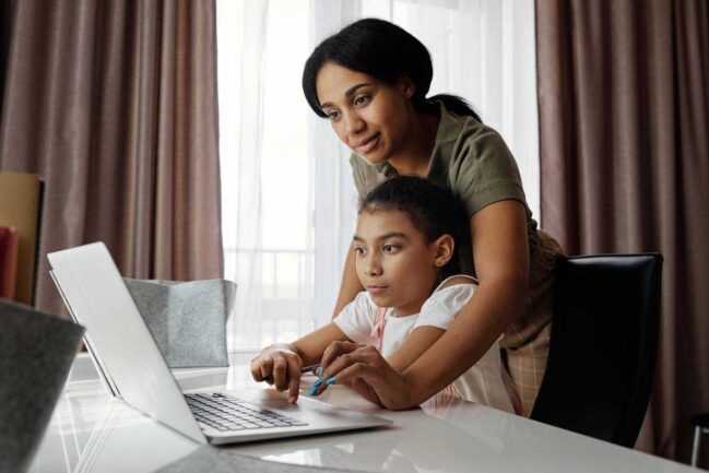 Mother helping daughter with school work