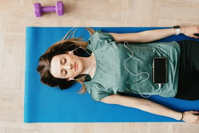 Woman lying on yoga mat practicing breathing